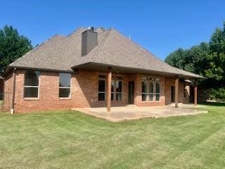 3805 Highridge, Edmond, OK 73003 - rear view of property featuring a chimney, a lawn, and a patio