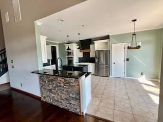 3805 Highridge, Edmond, OK 73003 - kitchen with stainless steel fridge with ice dispenser, dark countertops, hanging light fixtures, wood finished floors, and a peninsula