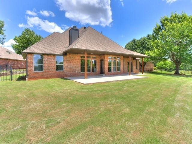 3805 Highridge, Edmond, OK 73003 - back of house with a chimney, brick siding, a patio area, and roof with shingles