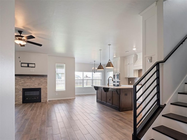 19608 Dalemead Way, Edmond, OK 73012 - kitchen with stainless steel appliances, light countertops, a ceiling fan, light wood-style flooring, and open floor plan