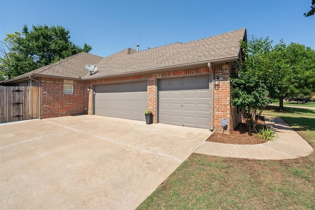 2917 Stafford Rd, Edmond, OK 73012 - view of side of home with an attached garage, driveway, brick siding, and a shingled roof