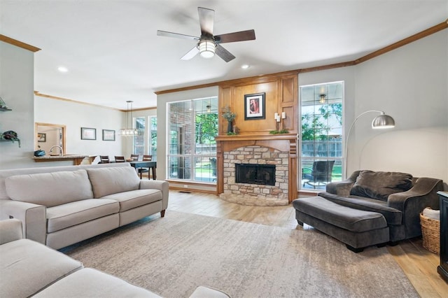 2917 Stafford Rd, Edmond, OK 73012 - living area featuring crown molding, light wood-style floors, a ceiling fan, recessed lighting, and a fireplace