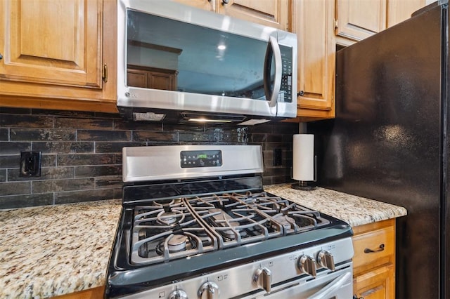 2917 Stafford Rd, Edmond, OK 73012 - kitchen featuring appliances with stainless steel finishes, decorative backsplash, and light stone countertops