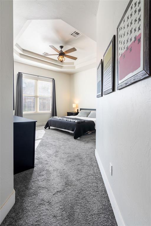 8300 NW 71st St, Oklahoma City, OK 73132 - carpeted bedroom with a raised ceiling and a ceiling fan