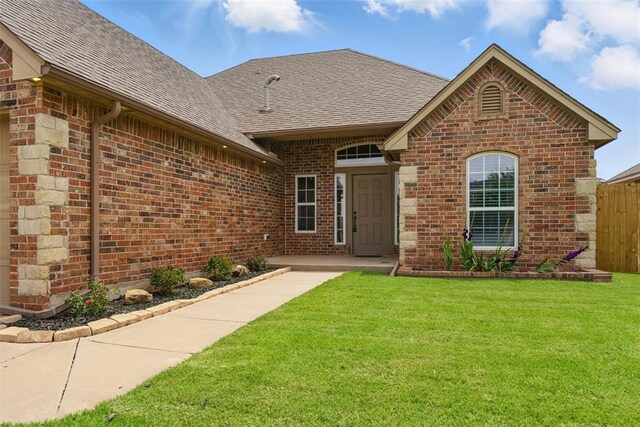 2716 Busheywood Dr, Yukon, OK 73099 - doorway to property featuring brick siding and roof with shingles