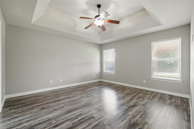 2716 Busheywood Dr, Yukon, OK 73099 - unfurnished room with a raised ceiling, dark wood-type flooring, and a ceiling fan