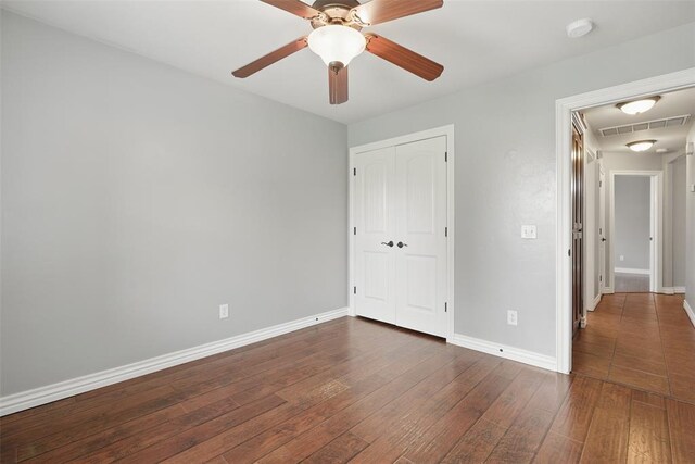 2716 Busheywood Dr, Yukon, OK 73099 - unfurnished bedroom featuring attic access, hardwood / wood-style flooring, a closet, and a ceiling fan