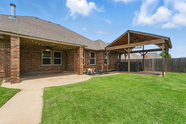 2716 Busheywood Dr, Yukon, OK 73099 - back of property featuring a hot tub, a ceiling fan, a patio area, and brick siding