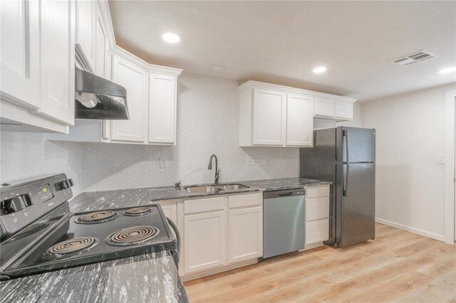 312 SE 45th St, Oklahoma City, OK 73129 - kitchen with stainless steel dishwasher, range with electric cooktop, freestanding refrigerator, exhaust hood, and white cabinetry