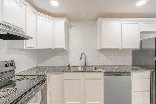 312 SE 45th St, Oklahoma City, OK 73129 - kitchen with appliances with stainless steel finishes, under cabinet range hood, dark stone counters, white cabinetry, and tasteful backsplash