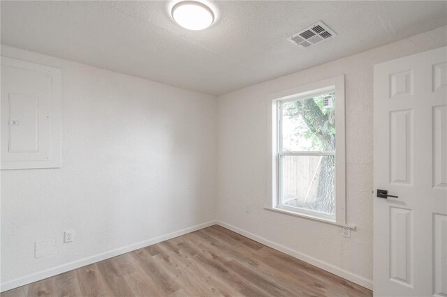 312 SE 45th St, Oklahoma City, OK 73129 - spare room featuring light wood-type flooring, electric panel, and a textured ceiling