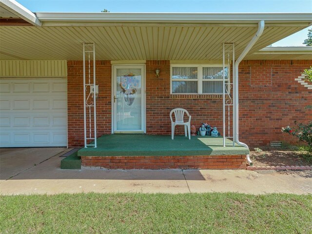 3113 SE 20th St, Oklahoma City, OK 73115 - property entrance featuring covered porch, brick siding, and a garage
