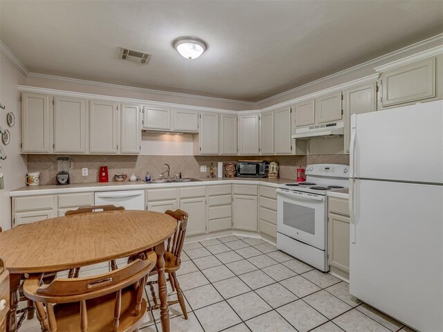 3113 SE 20th St, Oklahoma City, OK 73115 - kitchen featuring white appliances, under cabinet range hood, light countertops, ornamental molding, and tasteful backsplash