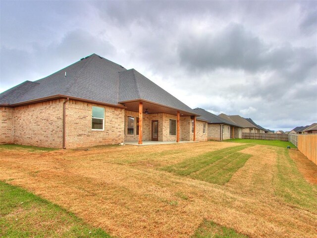 9320 NW 84th St, Yukon, OK 73099 - back of property with a patio, brick siding, roof with shingles, and a fenced backyard