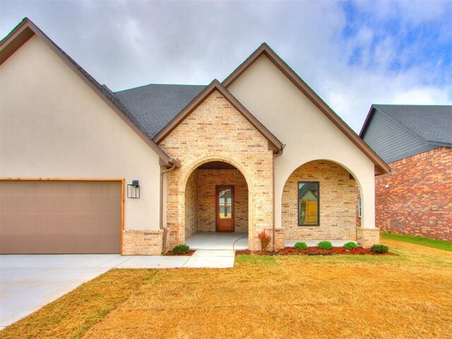 9320 NW 84th St, Yukon, OK 73099 - view of front facade featuring a front lawn, stucco siding, brick siding, and concrete driveway
