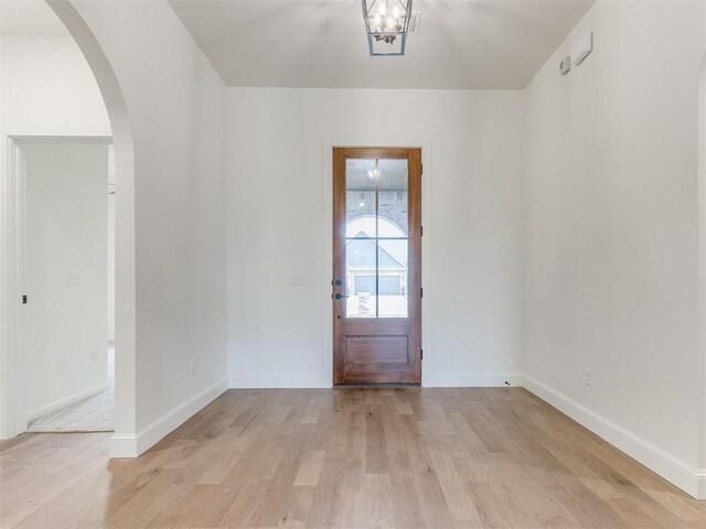 9320 NW 84th St, Yukon, OK 73099 - entryway with light wood-style flooring, arched walkways, and a chandelier