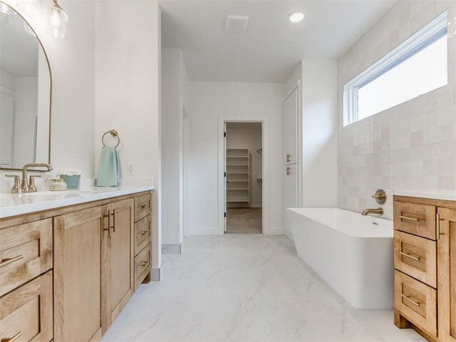 9320 NW 84th St, Yukon, OK 73099 - bathroom featuring vanity, a freestanding tub, marble finish floors, a spacious closet, and recessed lighting