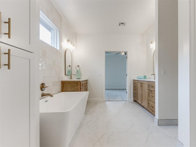 9320 NW 84th St, Yukon, OK 73099 - bathroom featuring a freestanding bath, two vanities, marble finish floors, and a ceiling fan