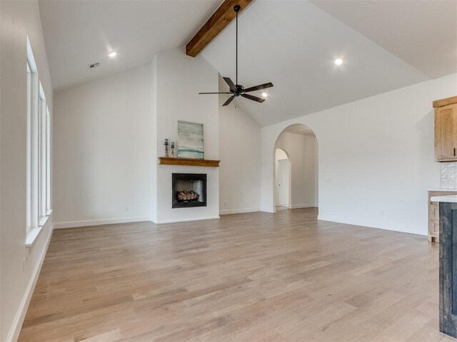 9320 NW 84th St, Yukon, OK 73099 - unfurnished living room featuring a fireplace, a ceiling fan, beam ceiling, arched walkways, and high vaulted ceiling