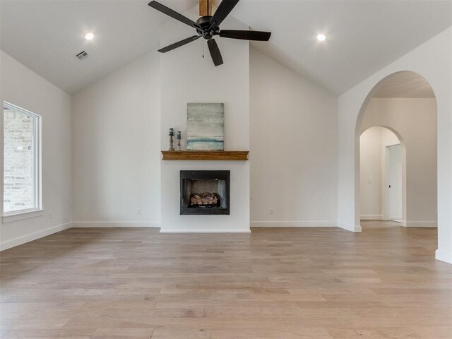 9320 NW 84th St, Yukon, OK 73099 - unfurnished living room featuring high vaulted ceiling, ceiling fan, light wood-style flooring, a fireplace, and arched walkways