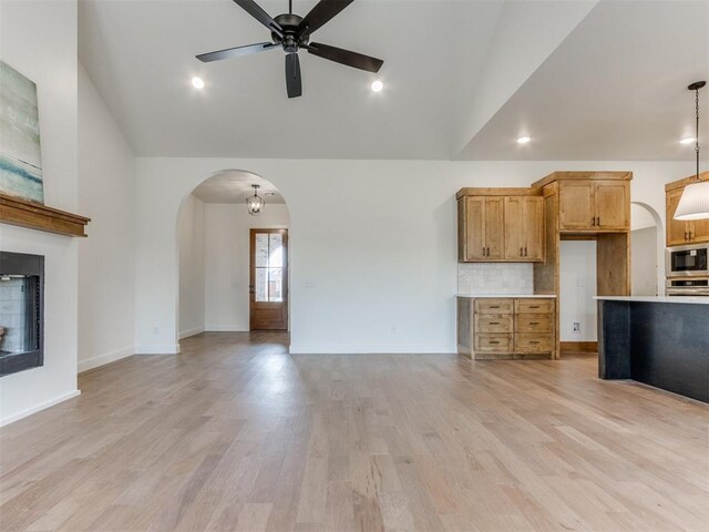 9320 NW 84th St, Yukon, OK 73099 - unfurnished living room with arched walkways, ceiling fan, high vaulted ceiling, light wood finished floors, and recessed lighting