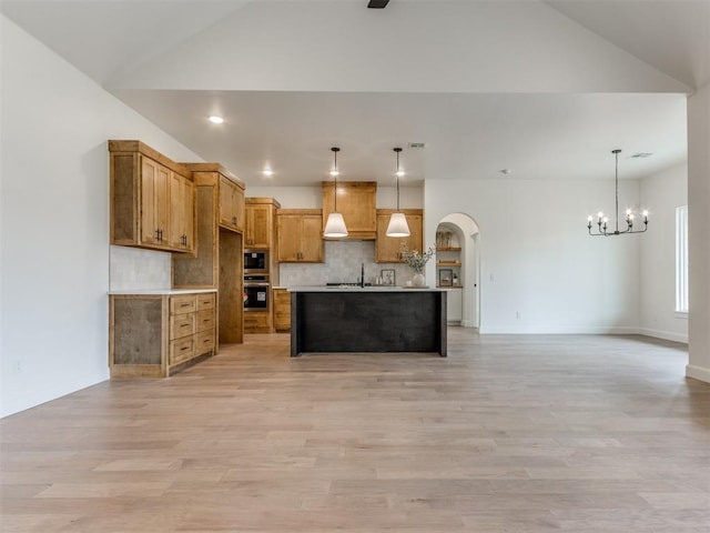 9320 NW 84th St, Yukon, OK 73099 - kitchen featuring oven, a chandelier, arched walkways, tasteful backsplash, and open floor plan