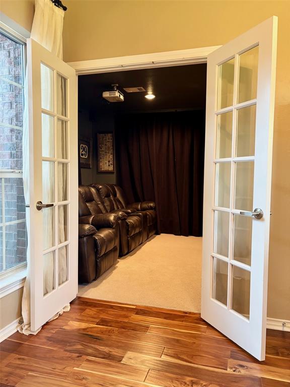 20301 Flowered Meadows Way, Edmond, OK 73012 - cinema with french doors and wood finished floors