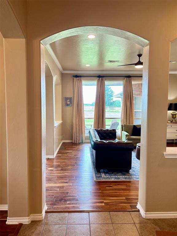 20301 Flowered Meadows Way, Edmond, OK 73012 - tiled living room with arched walkways and ornamental molding