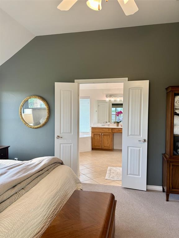20301 Flowered Meadows Way, Edmond, OK 73012 - bedroom with lofted ceiling and ensuite bathroom