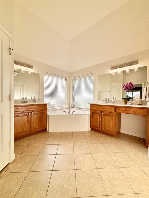 20301 Flowered Meadows Way, Edmond, OK 73012 - bathroom with tile patterned floors, two vanities, a bath, and lofted ceiling