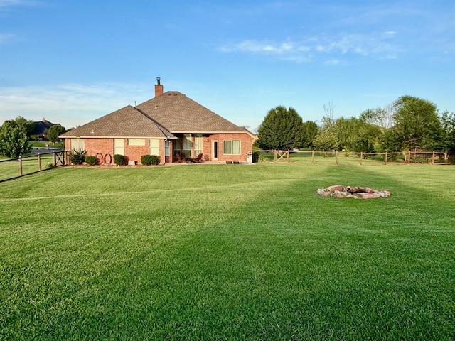 20301 Flowered Meadows Way, Edmond, OK 73012 - rear view of property featuring a fenced backyard, a chimney, an outdoor fire pit, and brick siding