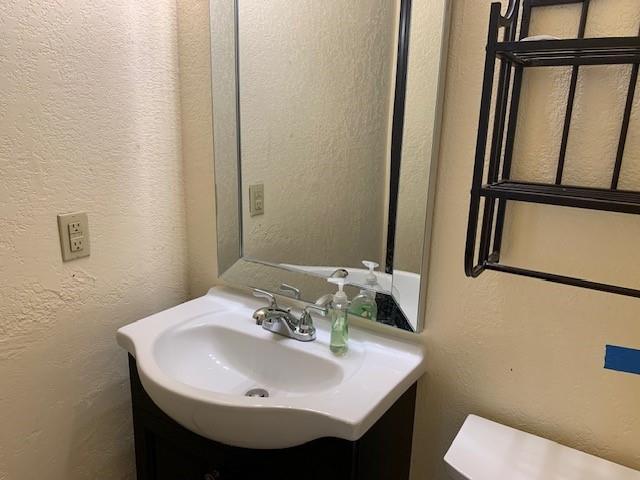 516 Ridgecrest Rd, Edmond, OK 73013 - bathroom with vanity and a textured wall