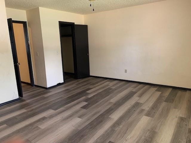 516 Ridgecrest Rd, Edmond, OK 73013 - unfurnished bedroom with a textured ceiling and wood finished floors