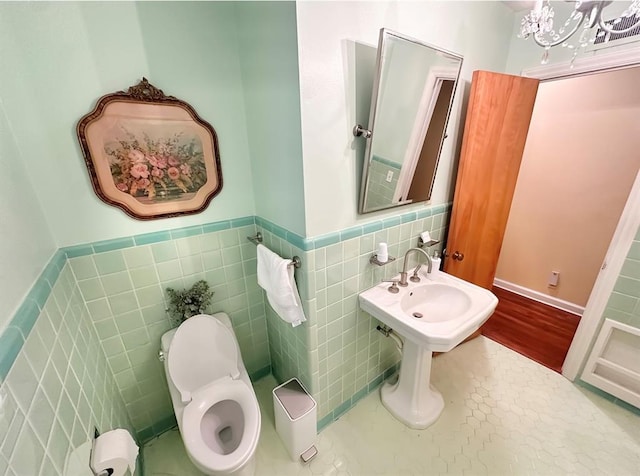 1516 N Hudson St, Altus, OK 73521 - bathroom featuring tile walls, a wainscoted wall, and wood finished floors