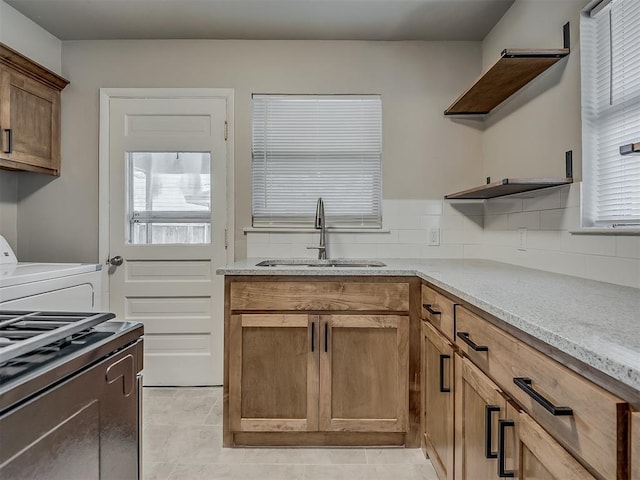 2104 Westchester Dr, Oklahoma City, OK 73120 - kitchen with washer / clothes dryer, open shelves, light stone counters, light tile patterned flooring, and stainless steel range oven
