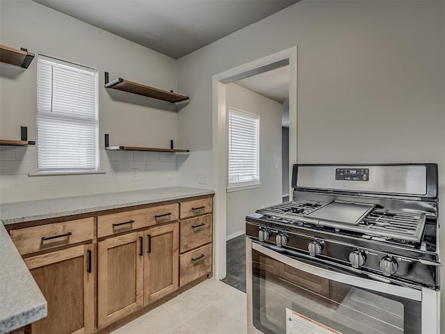 2104 Westchester Dr, Oklahoma City, OK 73120 - kitchen with stainless steel gas stove, open shelves, decorative backsplash, and brown cabinetry