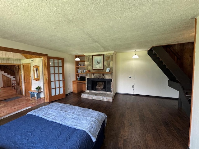 36166 Ew 1120th Rd, Seminole, OK 74868 - bedroom featuring wood finished floors, a stone fireplace, and a textured ceiling