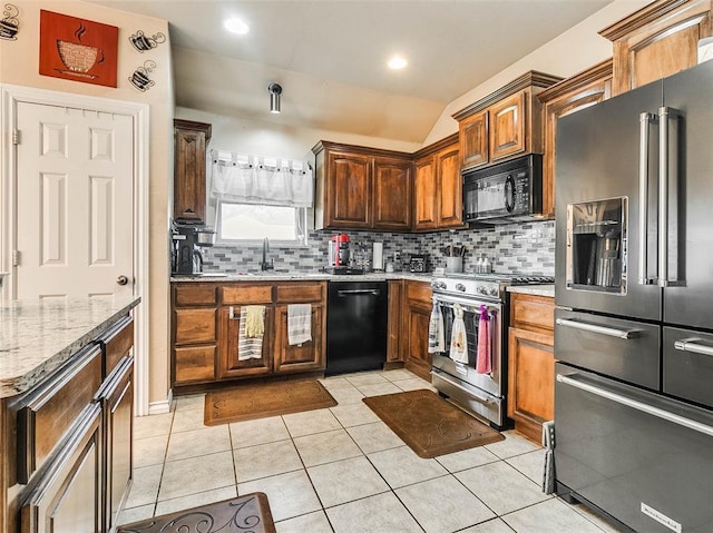 1201 W Churchill Way, Mustang, OK 73064 - kitchen featuring black appliances, decorative backsplash, light stone countertops, light tile patterned floors, and lofted ceiling