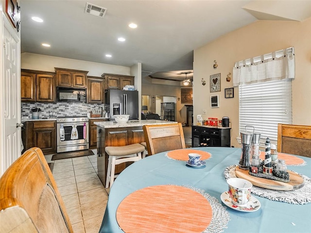 1201 W Churchill Way, Mustang, OK 73064 - kitchen with appliances with stainless steel finishes, a center island, decorative backsplash, light tile patterned flooring, and recessed lighting