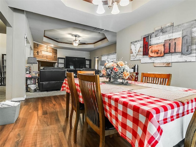 1201 W Churchill Way, Mustang, OK 73064 - dining room featuring a tray ceiling, wood finished floors, ceiling fan, and a chandelier