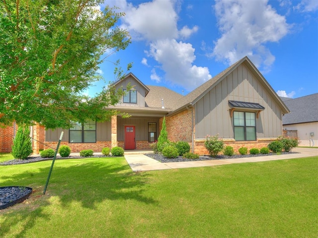 16405 Brookefield Dr, Edmond, OK 73013 - view of front facade featuring board and batten siding, brick siding, a front yard, and roof with shingles