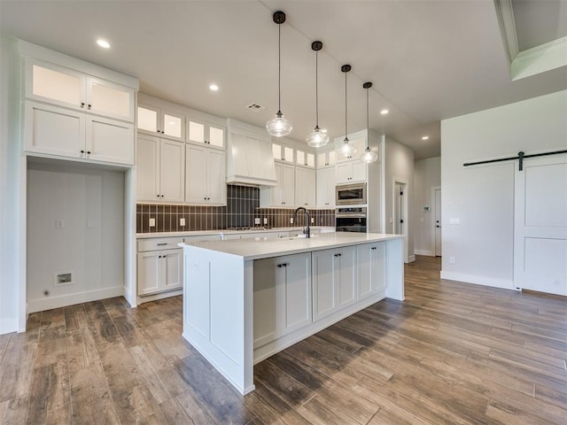 16405 Brookefield Dr, Edmond, OK 73013 - kitchen with stainless steel appliances, premium range hood, a barn door, white cabinetry, and light countertops