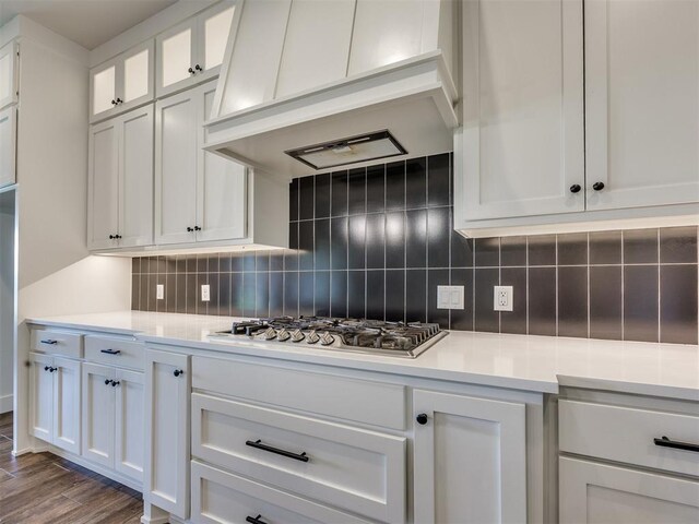 16405 Brookefield Dr, Edmond, OK 73013 - kitchen with wall chimney exhaust hood, white cabinets, light countertops, and backsplash