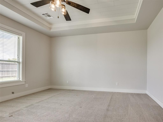 16405 Brookefield Dr, Edmond, OK 73013 - carpeted empty room featuring a tray ceiling, plenty of natural light, and a ceiling fan