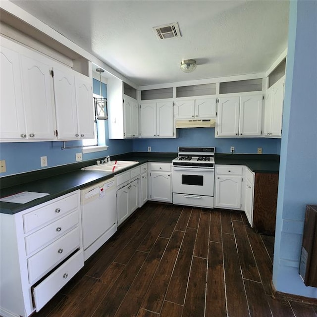 2413 7th St, Prague, OK 74864 - kitchen featuring white appliances, under cabinet range hood, dark countertops, and dark wood-style flooring