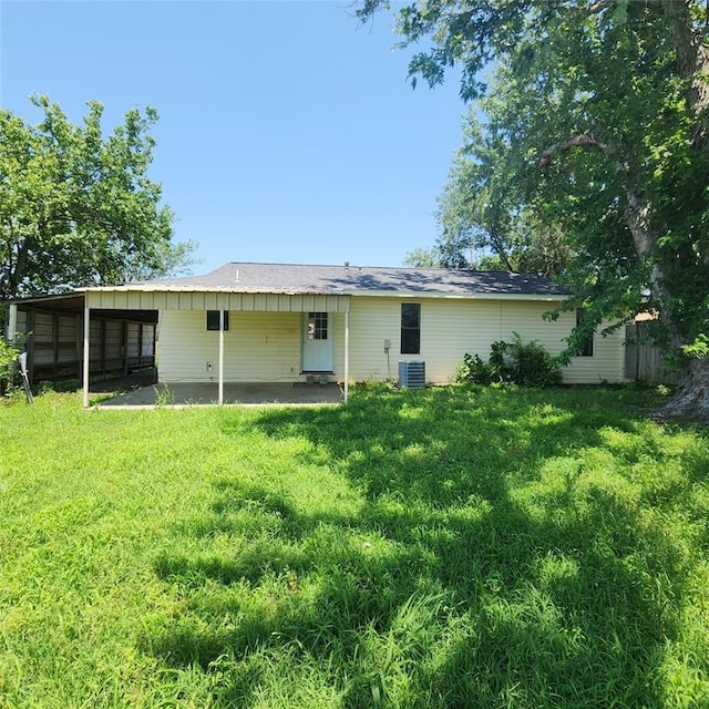 2413 7th St, Prague, OK 74864 - back of property featuring a lawn, a carport, and a patio area