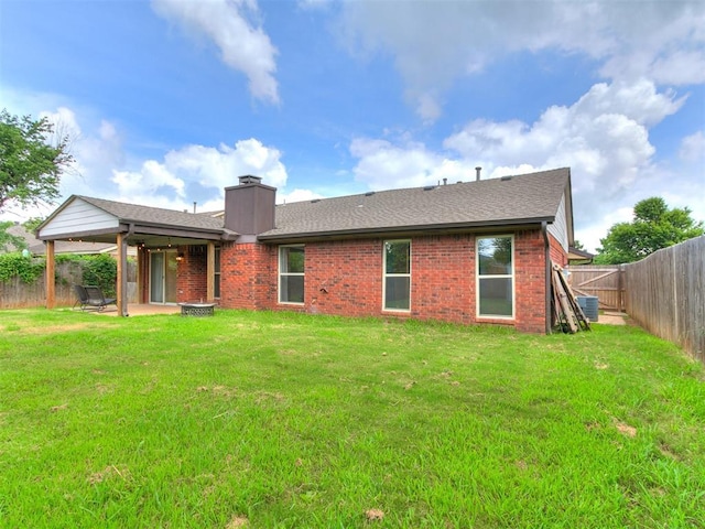 1408 Chimney Hill Rd, Yukon, OK 73099 - back of property featuring a fenced backyard, a chimney, a patio area, brick siding, and roof with shingles