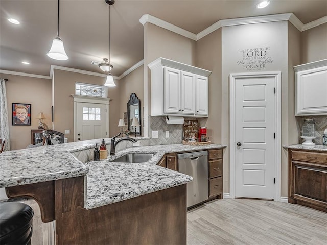 2204 Cale Cv, Yukon, OK 73099 - kitchen with dishwasher, light wood-style floors, backsplash, white cabinets, and light stone counters