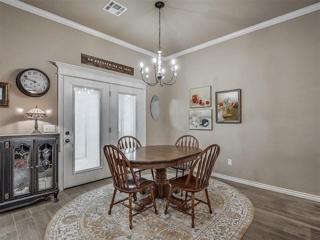 2204 Cale Cv, Yukon, OK 73099 - dining area featuring wood finished floors, a chandelier, and crown molding