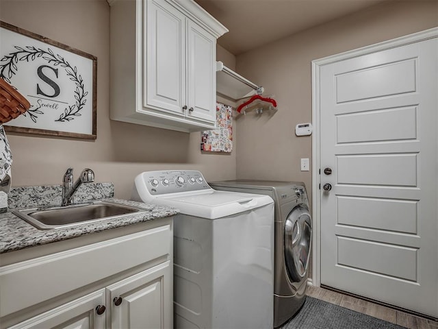 2204 Cale Cv, Yukon, OK 73099 - laundry room with cabinet space, washer and clothes dryer, and wood finished floors